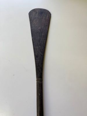an old wooden paddle sitting on top of a white table