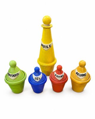 quatre récipients en plastique de couleurs différentes posés sur une surface blanche