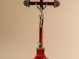 an image of a red crucif with a statue of jesus on the cross