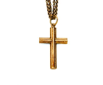 pendentif en forme de croix en or, suspendu à une chaîne en or, sur fond blanc