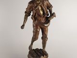 bronze statue of a man with a hat and a cane