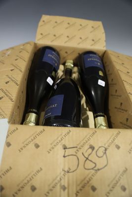 trois bouteilles de vin dans un carton sur une table