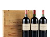three bottles of red wine in front of a wooden box