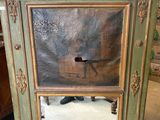 a mirror that is sitting on the floor in front of a cabinet