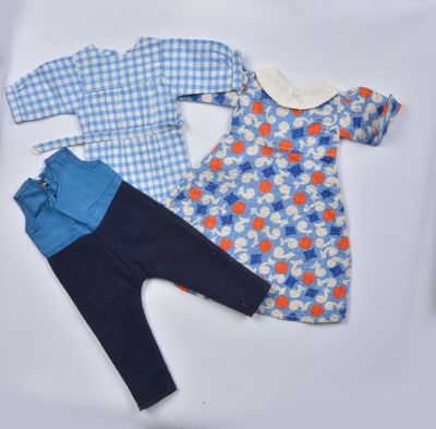 une photo d'un ensemble de vêtements pour bébé posé sur une surface blanche
