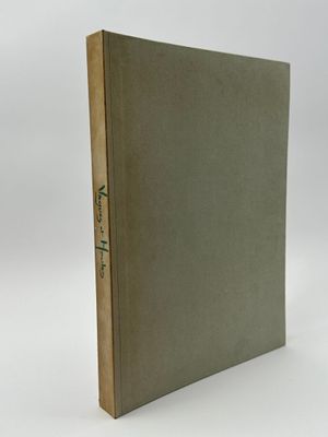 un livre à la couverture verte posé sur une surface blanche