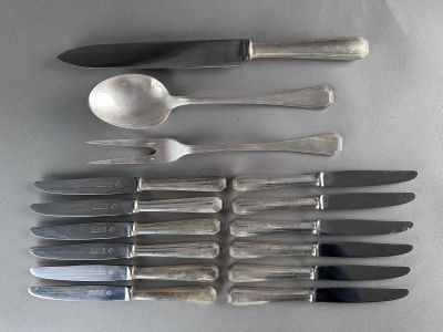 many different types of knives and spoons laid out on a table