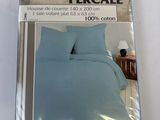 emballage d'un lit avec une couette bleue et deux oreillers