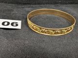 un gros plan d'une bague en or posée sur un tissu noir