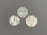 trois éléments en argent et en nacre sur un fond gris