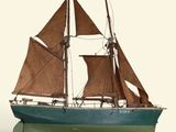 a small model of a sailboat on a white surface