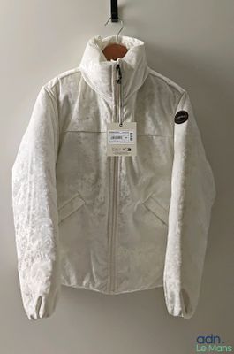 une photo d'une veste blanche accrochée à un mur