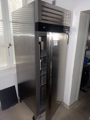 a stainless steel refrigerator in a kitchen with a window