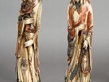 two asian figurines of a woman and a man holding a child