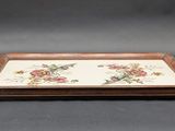 a wooden tray with flowers on it sitting on a table