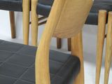 four chairs and a bench in a room with white walls