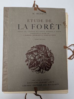 un vieux livre à la couverture marron posé sur une surface blanche