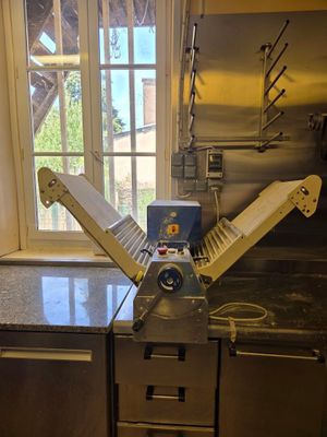 une photo d'une cuisine avec un coupe-pizza posé au milieu du plan de travail