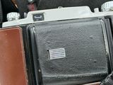 a brown and black camera with a brown strap on it