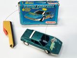 une petite voiture verte et une petite voiture jaune devant une boîte