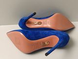 pair of blue high heeled shoes on a white surface