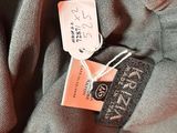 the label on the top of a gray shirt is attached to the bottom of the shirt