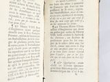 a book open on a white surface with black writing