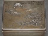 a silver box with a picture of a mountain in the background