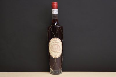an old bottle of wine sitting on top of a wooden table