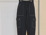 un pantalon noir suspendu à un portant devant un mur blanc