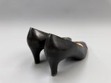 a close up of a pair of black shoes on a white surface