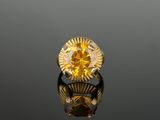 an image of a yellow diamond ring sitting on top of a reflective surface