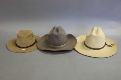 three hats are lined up on a table with a gray background