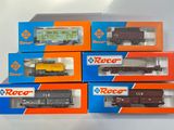 six boîtes contenant des trains miniatures, posées sur une surface blanche