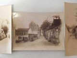 two old photos of a street and a building are hanging on a wall
