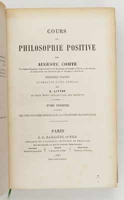 un livre ouvert posé sur une table blanche, avec une plante dessus