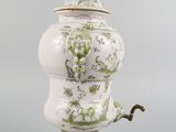 a white vase with a green and white design on it