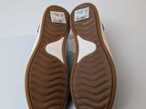 the bottom of a pair of brown and white slippers on a white surface