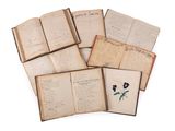 several open books with flowers on them sitting on a white surface