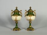 paire de vases verts et blancs rehaussés de touches dorées, posés sur des socles
