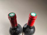two bottles of wine sitting next to each other on a table
