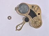 a close up of a small brass object on a white surface