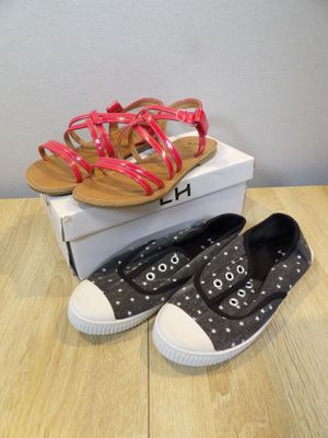 two pairs of black and white shoes on top of a box