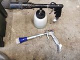 a spray gun, a bottle of paint, and a toothbrush on the floor