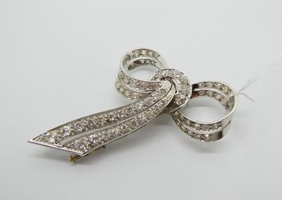 broche en forme de nœud ornée de pierres en cristal sur fond blanc