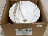 un bol blanc posé dans une boîte posée par terre