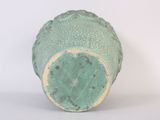 a green vase that is sitting on a white surface