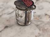 un bocal en verre contenant une perle rouge