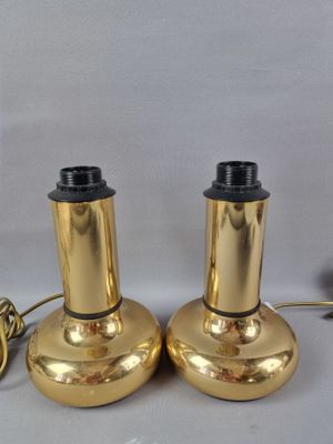 une paire de lampes plaquées laiton avec des abat-jours noirs sur fond blanc