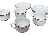 several white and blue cups and saucers sitting on top of each other
